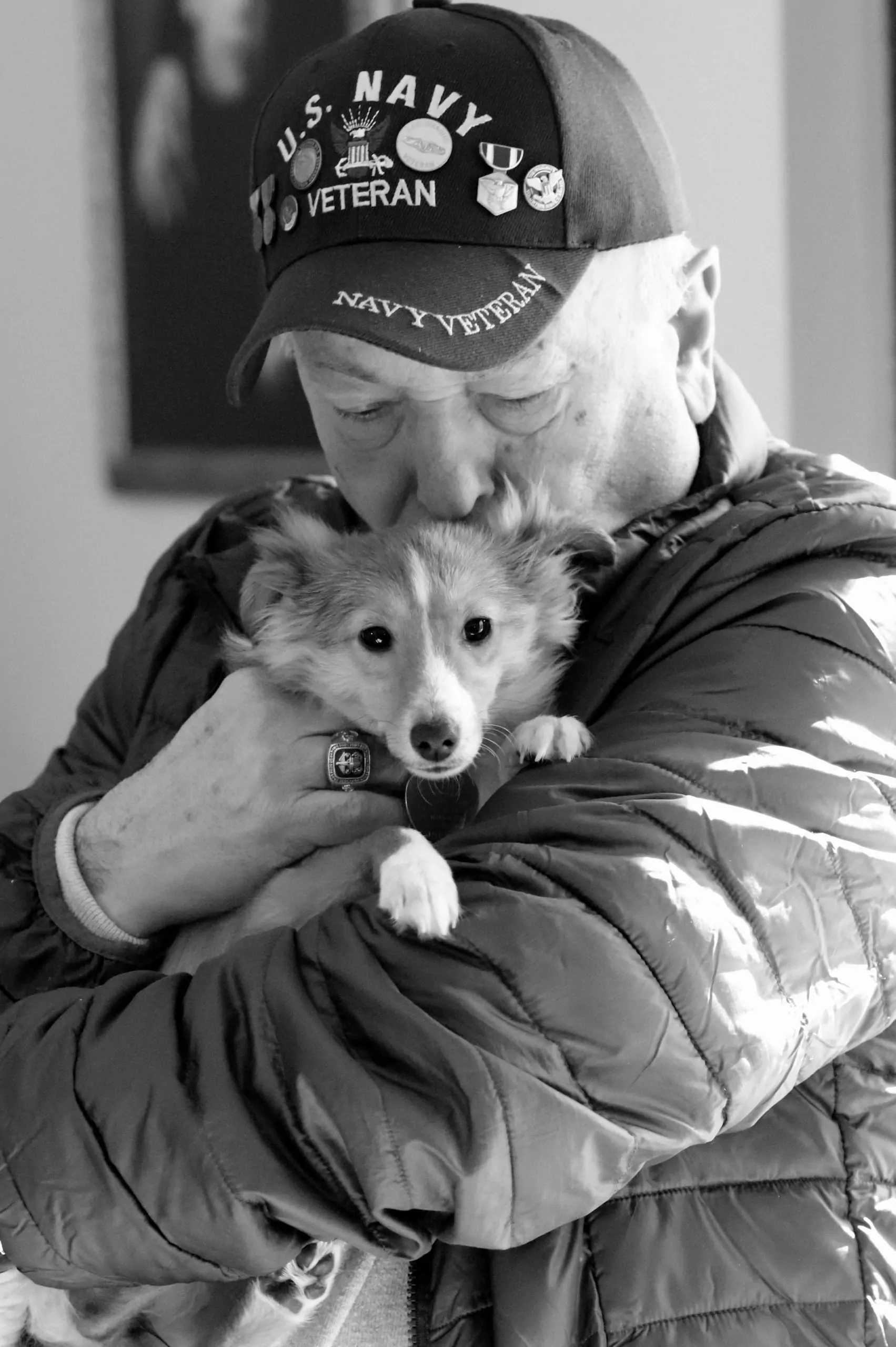 A touching moment of a Navy veteran holding a puppy, showcasing love and companionship.